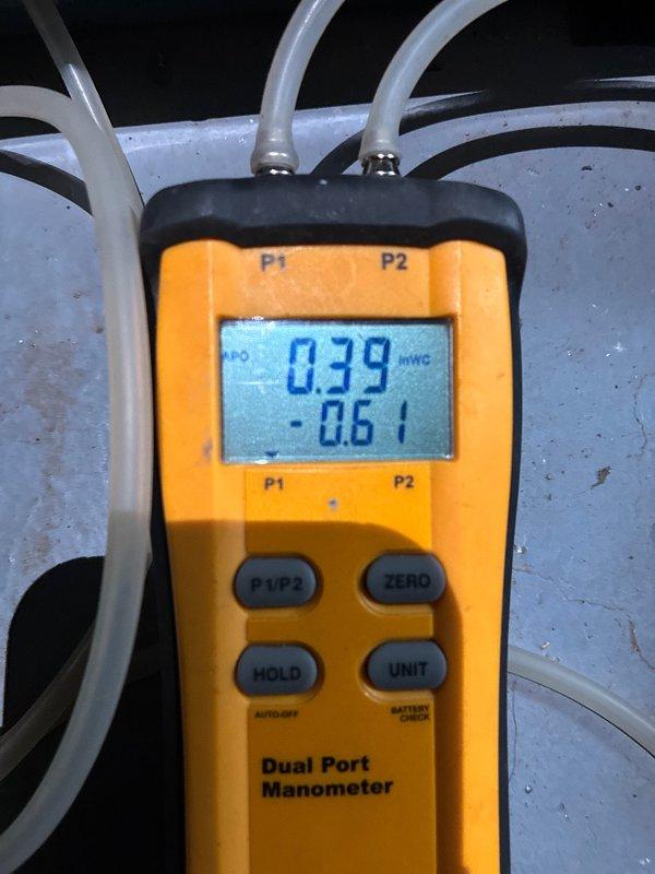 Completed full HVAC system installation including 96% efficiency furnace and air conditioning system. Rigging equipment was utilized to hoist outdoor condensing unit 10-15 feet to rooftop location. Post-installation testing performed using digital manometer to verify proper static pressure readings across the system, with measurements showing 0.39 inWG and -0.61 inWG differential. New galvanized ductwork installed in basement mechanical room with proper connections and transitions to existing infrastructure.