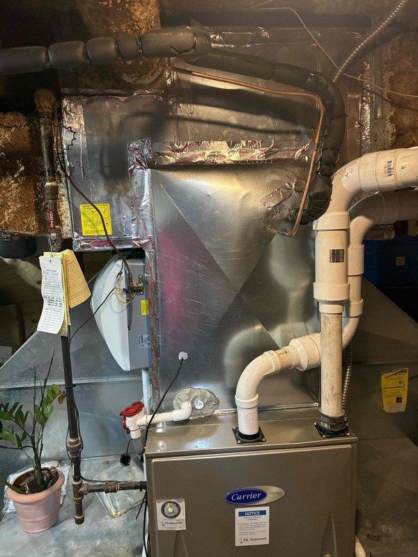 Completed air conditioning system installation including outdoor condensing unit and indoor evaporator coil integration with existing Carrier furnace. Installed new refrigerant line set with proper insulation, established electrical disconnect with 45-amp time-delay fuses rated for 250V AC, and ran PVC condensate drain lines with appropriate trap configuration. System was pressure tested, evacuated, charged to manufacturer specifications, and verified operational. All components secured per code requirements and manufacturer guidelines.