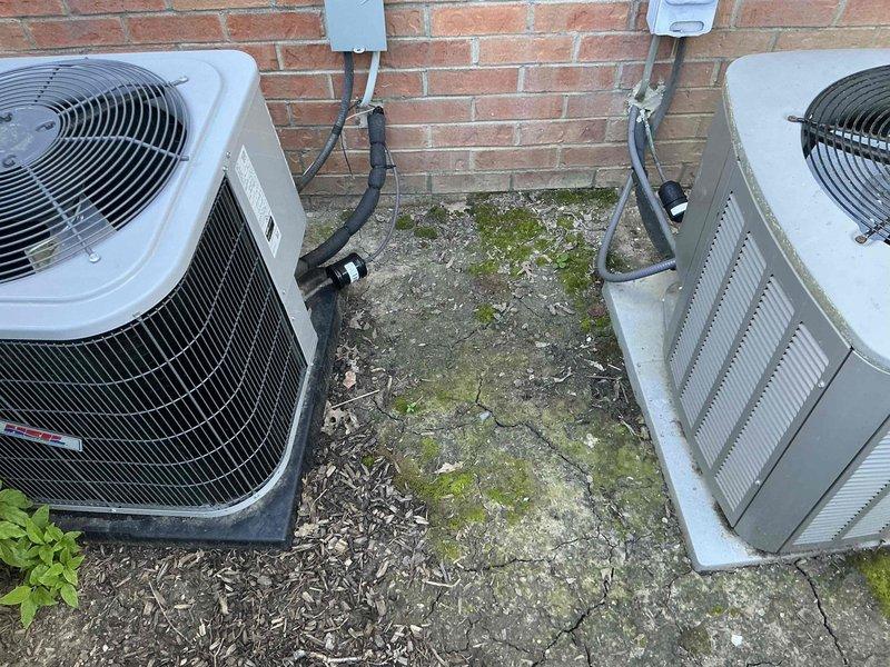 Completed comprehensive room-by-room load calculation survey for residential property to determine proper HVAC system sizing requirements, calculating total cooling load of 29,000 BTU and heating load of 71,212 BTU. Presented three-tiered full system replacement options featuring Goodman air conditioning and gas furnace combinations: Good tier with up to 13.4 SEER and 80% AFUE efficiency, Better tier with up to 14 SEER and 96% AFUE efficiency, and Best tier with up to 16 SEER and 96% AFUE efficiency. Documented existing outdoor condenser units positioned on weathered concrete pad showing significant age and deterioration, with biological growth present on pad surface indicating need for system replacement.