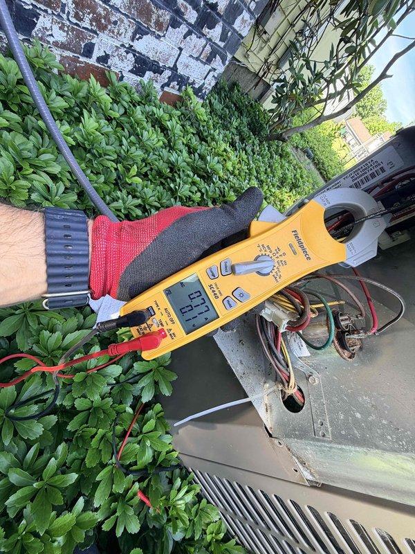 Responded to no cooling complaint on 15+ year old central air conditioning system. Upon arrival, found outdoor condensing unit with no airflow and wireless thermostat displaying connectivity issues with audible buzzing present. Performed electrical diagnostics on outdoor unit using digital multimeter to test voltage and current readings at compressor and contactor. Testing revealed low voltage reading of 1.7 on electrical components, indicating potential failure in start capacitor or compressor windings. Accessed outdoor unit's electrical compartment to inspect internal wiring, connections, and capacitor condition. Given the age of the equipment and diagnostic findings, discussed repair versus replacement options with homeowner for this aging system.