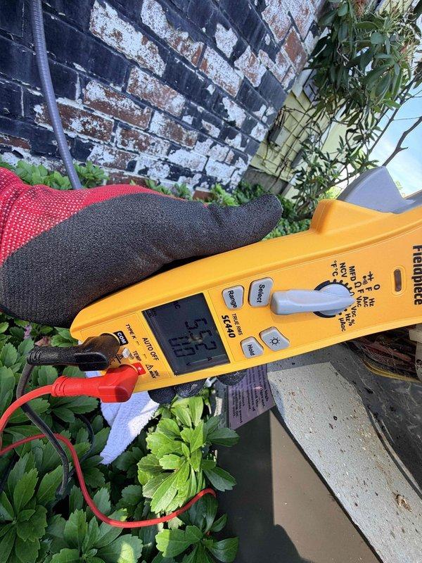 Responded to no cooling complaint on 15+ year old central air conditioning system. Upon arrival, found outdoor condensing unit with no airflow and wireless thermostat displaying connectivity issues with audible buzzing present. Performed electrical diagnostics on outdoor unit using digital multimeter to test voltage and current readings at compressor and contactor. Testing revealed low voltage reading of 1.7 on electrical components, indicating potential failure in start capacitor or compressor windings. Accessed outdoor unit's electrical compartment to inspect internal wiring, connections, and capacitor condition. Given the age of the equipment and diagnostic findings, discussed repair versus replacement options with homeowner for this aging system.