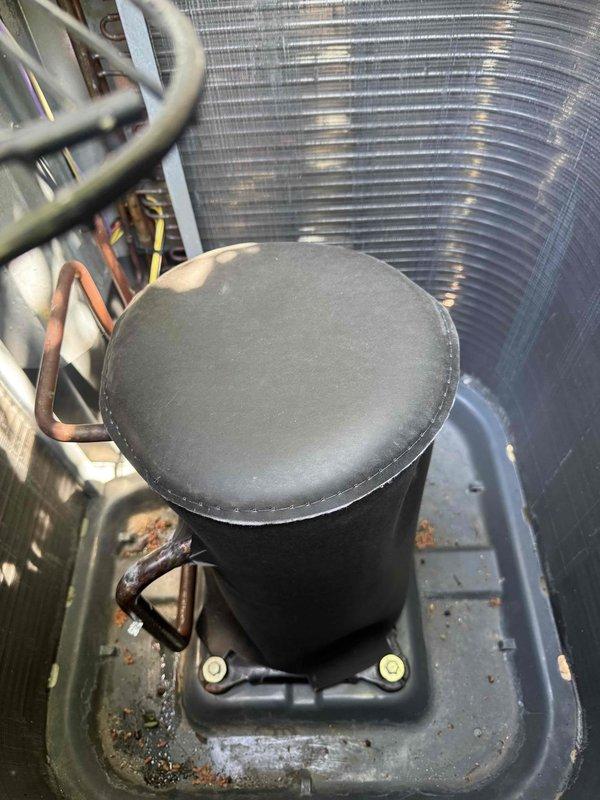 Installed compressor sound blanket jacket on outdoor condensing unit to reduce operational noise levels. Replaced system air filter to ensure proper airflow and maintain equipment efficiency. Documented installation with photographs showing compressor jacket properly secured to mounting bracket and existing refrigerant lines, electrical connections, and condenser coil configuration.