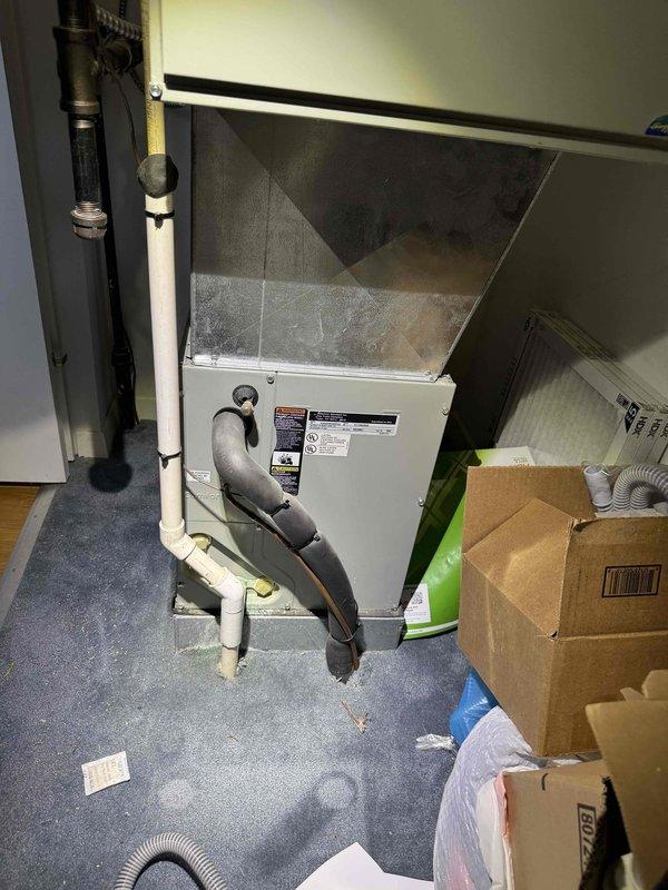 # HVAC Service Call - No Cooling Condition

Responded to service call for central air conditioning system with no cooling capability. Upon arrival, customer reported complete loss of cooling function with system age unknown.

## Diagnostic Procedures

Performed comprehensive system evaluation of residential split-system air conditioning unit located in interior mechanical closet. Conducted visual inspection of air handler cabinet and associated components. Examined electrical connections at junction box and verified whip connector integrity to unit. Inspected condensate drain lines and refrigerant line connections at base of air handler.

Evaluated ductwork connections and flexible duct routing from air handler. Checked system labels and manufacturer specifications on equipment panels. Assessed overall condition of installation including clearances and accessibility in confined mechanical space.

## Findings

System inspection revealed air handler unit in mechanical closet with standar