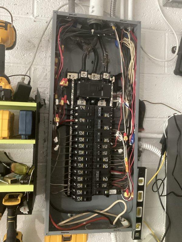 Performed comprehensive electrical inspection of commercial control system and main distribution panel. Documented contactor panel installation featuring centralized relay device with multi-phase wiring connections, yellow crimp terminals, and proper cable management. Verified integrity of electrical connections including red, black, white, and tan conductors routed through conduit and flexible metal whip. Inspected main electrical panel containing dual columns of circuit breakers with mixed individual and bundled conductor wiring, confirming proper wire nut connections and organized circuit arrangements. All components photographed for service records.