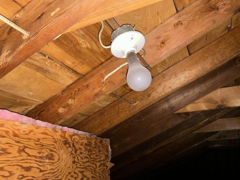 Conducted site assessment for customer requesting mini split installation options and separate quote for full ductwork system in attic with outdoor AC unit. Customer currently has boiler heat and is exploring cooling solutions. Documented attic space with exposed wooden joists and unfinished ceiling structure, noting existing electrical wiring and basic lighting fixture, as well as basement area with concrete block walls, exposed floor joists, and available space for potential equipment placement.