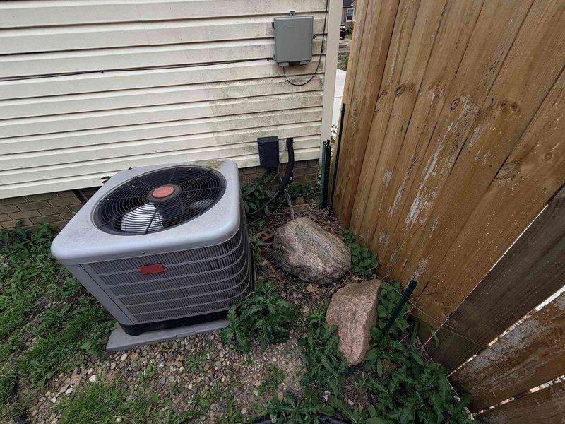 Responded to no-cooling complaint on central air conditioning system with reported loud vibration noise and inability to maintain thermostat setpoint. Upon arrival, inspected outdoor condenser unit and indoor air handler located in attic space. Identified aging equipment with mechanical failure requiring immediate attention. Due to system age exceeding 10 years and extent of necessary repairs, recommended complete system replacement. Customer approved replacement of existing unit with new high-efficiency system. Removed old condenser unit from exterior gravel pad and disconnected indoor air handler from ductwork and refrigerant lines. Installed new outdoor condensing unit on existing concrete pad, ensuring proper leveling and clearances from structure and fence line. Mounted new air handler in attic space, connecting to existing flexible ductwork and establishing new refrigerant line set. Performed vacuum and refrigerant charge per manufacturer specifications. Tested system operation, 