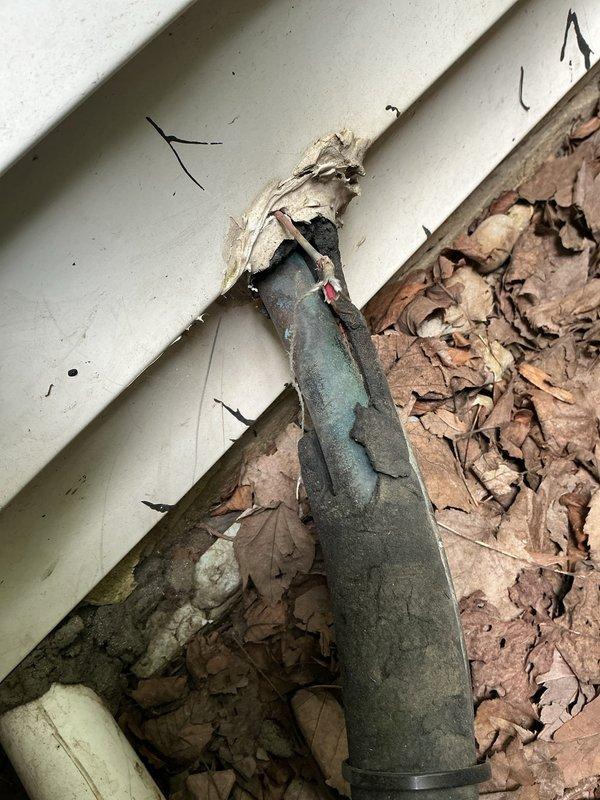 Responded to no cooling complaint on residential air conditioning system. Upon arrival, performed visual inspection of exterior and interior components. Discovered significant debris accumulation including leaves and organic matter blocking airflow around refrigerant line set and within accessible areas near equipment. Refrigerant lines showed deteriorated insulation with exposed sections requiring attention. Cleared debris from around penetration points and accessible areas to restore proper airflow. System components showed signs of inadequate maintenance and environmental exposure contributing to reduced performance.
