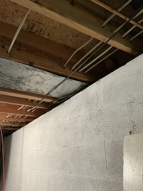 Conducted estimate for air conditioning system replacement on 35-year-old unit with burnt wiring. Evaluated existing equipment in basement installation, documented condition with photos showing exposed ceiling joists and concrete block wall construction, and presented customer with replacement options for failed system.