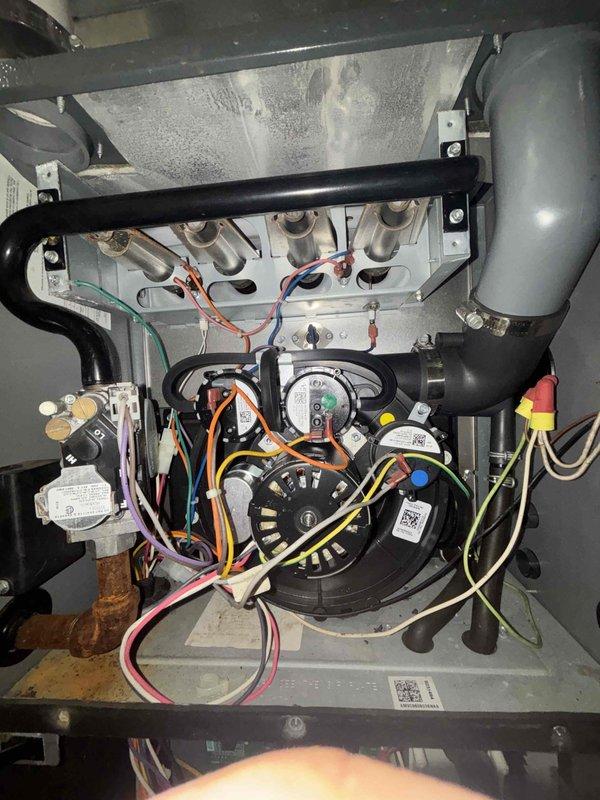 # HVAC Cooling System Maintenance

Completed scheduled preventive maintenance on residential cooling system. Performed comprehensive inspection of furnace and air handler components, including blower motor assembly, gas valve connections, and electrical wiring harnesses. Documented heavy dust accumulation on blower motor housing and electrical components. Inspected all visible brass fittings, copper refrigerant lines, and condensate drainage system for proper operation. Verified electrical connections across multiple wire runs including control circuits. Photographed internal cabinet components and blower assembly for service records. All mechanical and electrical systems found operational during inspection. System ready for continued cooling season operation.