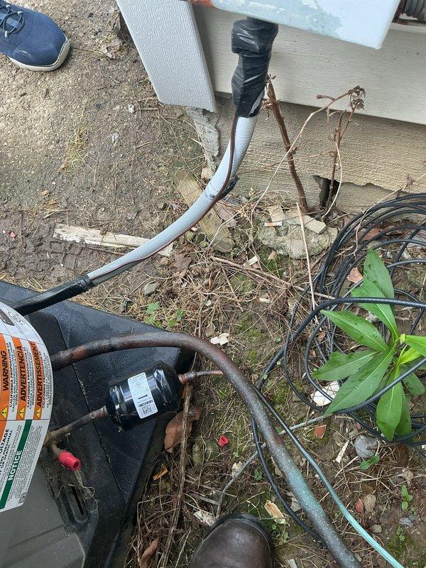 Responded to no-cooling complaint and performed diagnostic inspection of residential air conditioning system. Upon arrival, found outdoor condensing unit with significant debris accumulation around equipment and restricted airflow conditions. Cleared leaves, twigs, and organic matter from base of unit and surrounding area. Inspected refrigerant lines, electrical connections, and condensate drainage system. Verified proper operation of compressor and condenser fan motor after clearing obstructions and restoring adequate ventilation to unit.