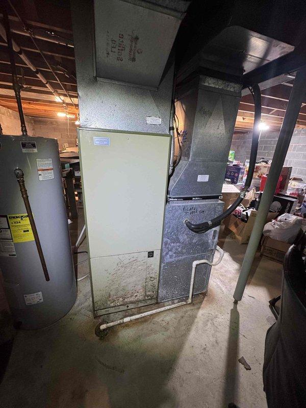 Responded to no cooling complaint on residential split system. Upon arrival, performed system diagnostic and visual inspection of furnace/air handler and connected AC components in basement mechanical room. Equipment showed signs of age with visible dirt accumulation and staining on lower panels. Assessed ductwork connections, refrigerant lines, and electrical components. System evaluated for proper operation and airflow issues identified during troubleshooting process.