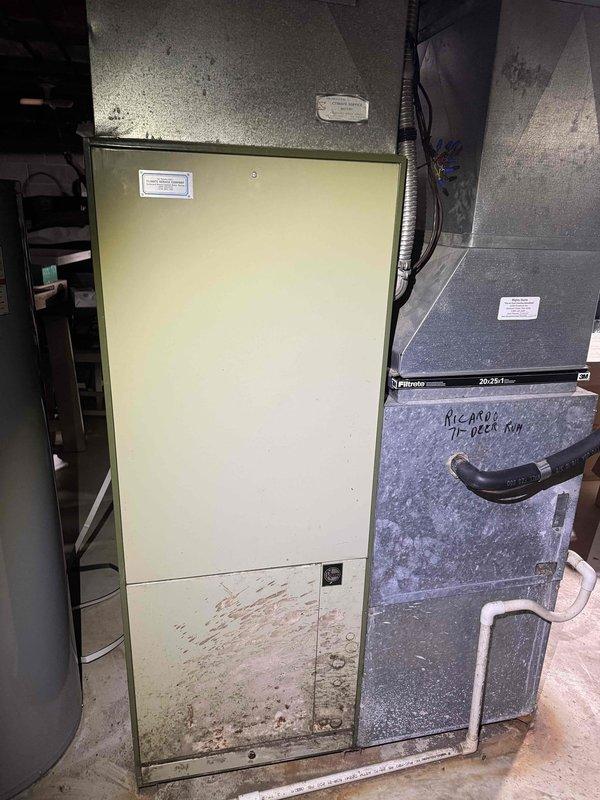 Responded to no cooling complaint on residential split system. Upon arrival, performed system diagnostic and visual inspection of furnace/air handler and connected AC components in basement mechanical room. Equipment showed signs of age with visible dirt accumulation and staining on lower panels. Assessed ductwork connections, refrigerant lines, and electrical components. System evaluated for proper operation and airflow issues identified during troubleshooting process.