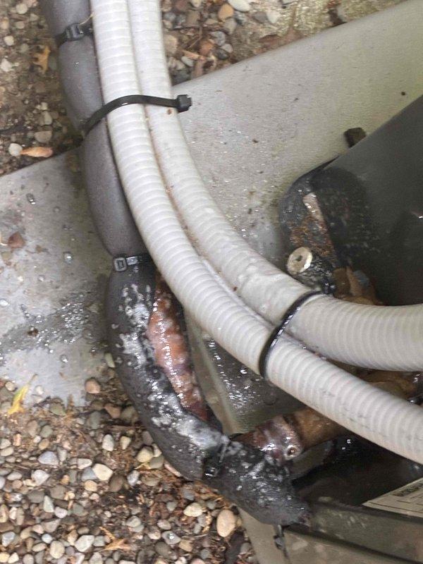 Responded to no cooling call and performed diagnostic evaluation of air conditioning system. Upon inspection, found system experiencing refrigerant leak as evidenced by moisture staining visible at condensate area and abnormal pressure readings on refrigeration gauges showing 1134 psig with superheat of 126°F and suction temperature of 36.4°F. Documented system conditions with diagnostic equipment and photographic evidence of leak location near bundled refrigerant line sets secured with cable ties in attic space. Senior technician assessed situation given urgency of health-related concerns and determined immediate repair necessary to restore cooling operation.