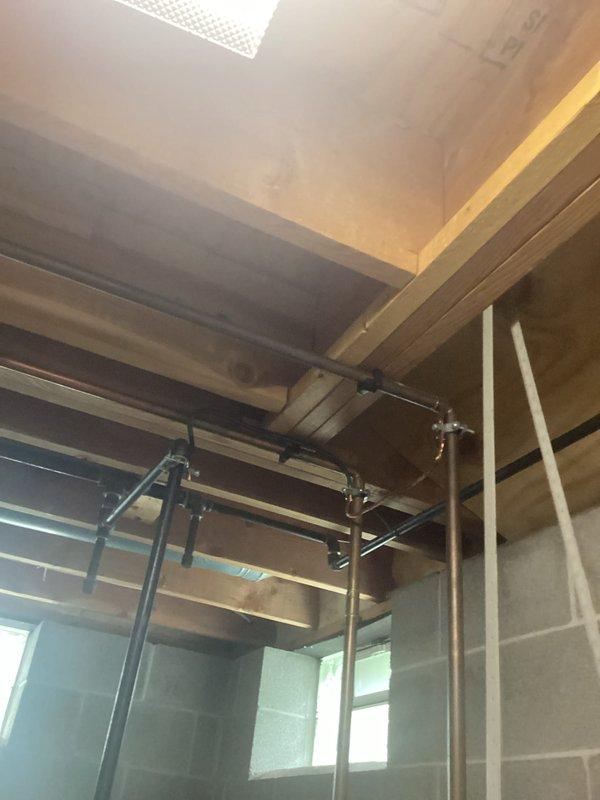 Conducted comprehensive electrical inspection of residential property during renovation phase. Documented electrical panel installation featuring dual-column circuit breaker configuration with main service lugs and proper wire routing through metal enclosure. Inspected exposed ceiling infrastructure including metallic conduit runs and mounting systems in construction area with visible structural elements. Captured photographic documentation of all electrical components and installations for compliance records.