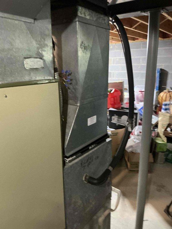 Responded to no cooling complaint at basement HVAC installation. Upon inspection, found aging air handler system with significant water damage and staining on lower cabinet panels, indicating possible condensate drainage issues or previous leakage. Evaluated existing equipment condition, noting deteriorated exterior surfaces and accumulated debris around unit base. Provided customer with replacement options for complete air conditioning and air handler system upgrade to restore cooling functionality and address underlying moisture-related concerns affecting equipment integrity.