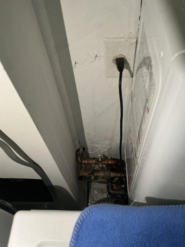 Conducted comprehensive electrical inspection of residential service panel and associated systems. Documented panel configuration showing proper circuit breaker arrangement, main disconnect connections, and wire routing throughout the enclosure. Verified neutral and ground bus bar installations, assessed wire management and securing methods, and confirmed GFCI outlet protection adjacent to panel location. Inspected utility area electrical and plumbing infrastructure, including outlet placement and cable routing in confined corner space near copper supply lines and shut-off valves.