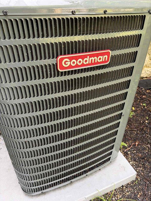 Completed scheduled preventive maintenance on residential Goodman air conditioning system. Performed comprehensive inspection of outdoor condenser unit, noting normal weathering and minor dust accumulation on exterior grille and cabinet surfaces. Verified condenser unit mounted securely on concrete pad with all fasteners intact. Inspected indoor air handler blower assembly, observing typical dust buildup on squirrel cage fan blades and motor components. Documented equipment condition through photographic records. System operational and functioning as designed.