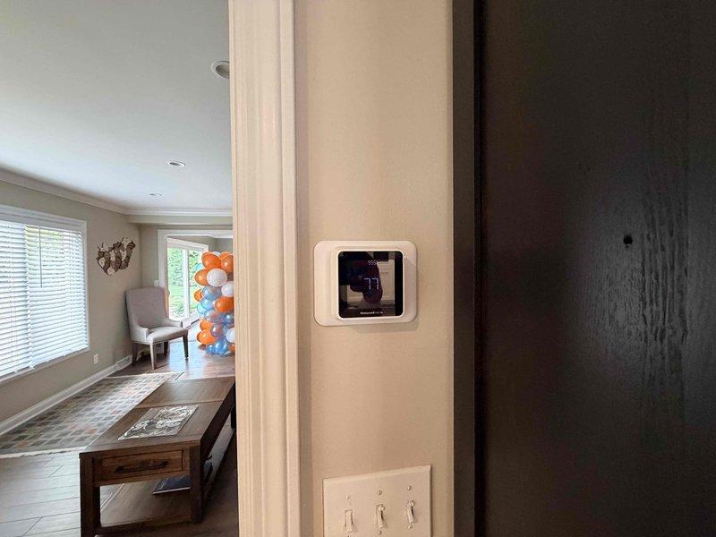 Responded to no cooling call at residential property. Upon arrival, found thermostat displaying but system not responding to cooling commands. Removed thermostat from wall plate to inspect wiring connections and verify proper 24V power supply. All wiring connections were secure and voltage readings confirmed adequate power to thermostat. Determined thermostat had failed and was not sending call signal to outdoor condensing unit. Discussed replacement options with homeowner and temporarily removed faulty thermostat for customer review of upgrade options before reinstallation of new unit.