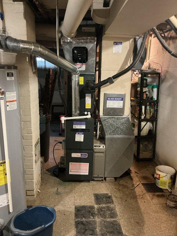 Responded to emergency service call for non-operational air conditioning system. Upon inspection, verified HVAC system functionality including furnace, air handler, and ductwork components. Confirmed proper operation of installed PREMIE UV-C air purification system with active blue indicator light functioning correctly within the duct system.