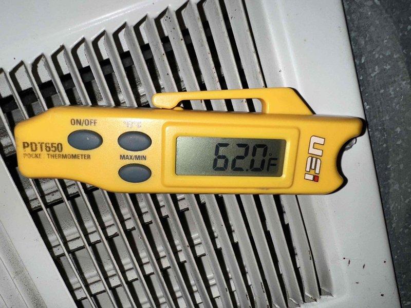 # HVAC Service Call - No Cooling Complaint

Responded to service call for central air conditioning system with no cooling complaint. Upon arrival, contacted customer as requested and proceeded with system diagnostics.

Performed temperature measurements at supply registers using calibrated digital thermometer. Initial readings indicated supply air temperature of 62.0°F at the register, suggesting insufficient cooling capacity or potential system malfunction. Normal supply air temperatures for properly operating AC systems typically range between 55-60°F with adequate temperature split from return air.

Conducted visual inspection of HVAC equipment located in basement mechanical room. System consists of forced air furnace with integrated cooling coil and standard ductwork configuration. Equipment observed alongside residential water heater in utility space. All major components accessed and visually assessed for obvious signs of failure or operational issues.

Documented equipment condi