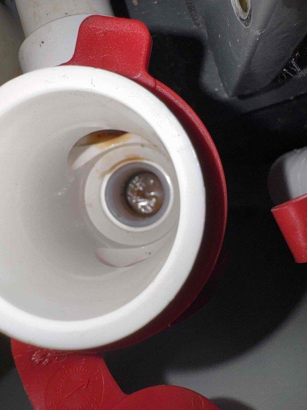 Responded to report of water leak on one-year-old air conditioning unit. Performed thorough inspection of condensate drain system and identified source of leakage at primary drain line connection. Inspected PVC drain piping, trap assembly, and drain pan for proper installation and functionality. Observed buildup and residue in drain components indicating potential blockage or improper drainage. Checked condensate flow and verified trap was holding water seal as designed. Documented findings with photos for further review and determination of necessary repairs to resolve leak issue.