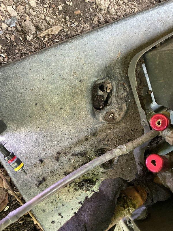 Responded to no cooling complaint for residential air conditioning system. Upon arrival, inspected outdoor unit and discovered severely corroded copper refrigerant line penetrating through foundation wall. Line showed extensive oxidation with green patina and orange-brown deterioration, indicating prolonged exposure to moisture and potential refrigerant leak. Documented condition of corroded piping and valve connections showing weathering and mineral deposits. System unable to maintain proper cooling due to compromised refrigerant lines requiring replacement and proper sealing at foundation penetration point.