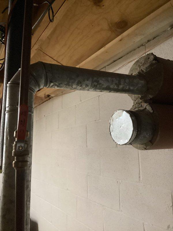 Responded to service call for tanked water heater producing lukewarm water. Performed diagnostic inspection of residential water heater unit located in basement mechanical room. Assessed unit specifications, examined inlet and outlet connections, and verified proper venting configuration through metallic exhaust pipe. Inspected surrounding plumbing infrastructure including copper supply lines and associated HVAC systems in utility area. Documented equipment condition and installation setup with photographic records showing water heater placement, wall-mounted utilities, and basement infrastructure. Provided assessment findings and recommendations to household representatives present during service visit.