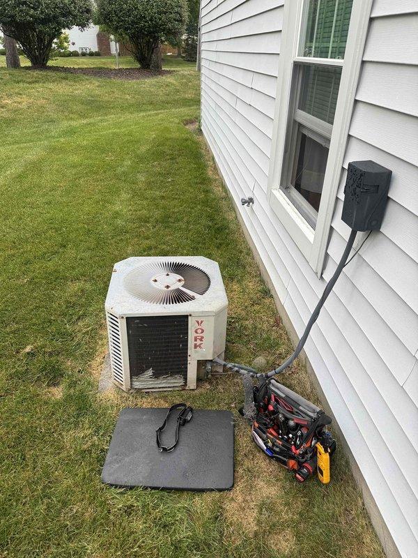 Performed comprehensive AC tune-up on 34-year-old cooling system. Removed heavy debris accumulation including lint, cottonwood seeds, and outdoor matter from condenser coil grille that was restricting airflow. Cleaned condenser coils, inspected electrical connections at disconnect box, checked refrigerant levels, tested fan motor operation, and verified system cooling capacity. Unit operational and running efficiently after maintenance despite age-related wear and minor rust on housing.