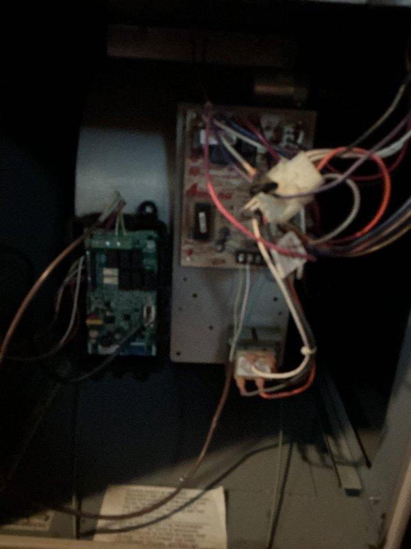 Responded to emergency no-cooling call and performed diagnostic inspection of residential HVAC system. Upon accessing the unit and removing panels, conducted thorough examination of internal components including blower motor assembly, electrical connections, and control board. Inspected wiring throughout the system, noting multiple wire connections between furnace components and air conditioning controls. Evaluated capacitor, control module, and associated electrical components for proper operation. Documented system condition with photographs showing internal cabinet layout, blower assembly, and electrical control components for service records.