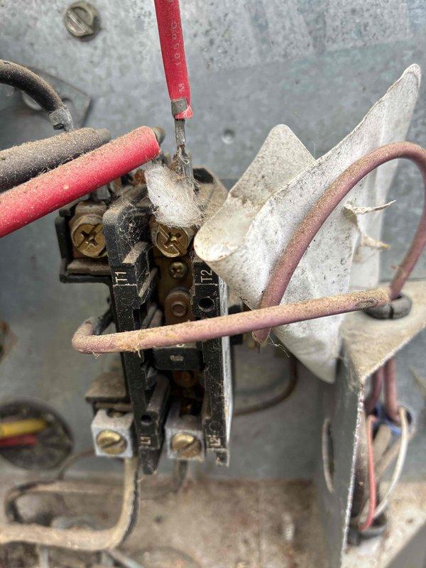 Responded to service call for air conditioning system not maintaining desired temperature at thermostat setpoint. Upon arrival, found 20-year-old outdoor condensing unit with aged electrical components showing significant wear and weathering. Performed diagnostic evaluation of system operation and inspected electrical connections including contactor and run capacitor. Documented condition of electrical components with photographs showing deteriorated wiring insulation, dust accumulation, and aged capacitor with faded labeling. Confirmed best contact number for follow-up communication regarding system performance and repair recommendations for aging equipment.