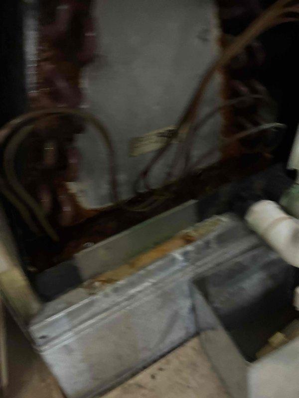 Responded to call for air conditioning system leaking from supply vent. Upon inspection, discovered severely corroded evaporator coil and condensate drain system with extensive rust buildup on copper refrigerant lines and connections. The condensate drain pan showed significant deterioration with mineral deposits and corrosion staining, indicating long-term moisture issues and inadequate drainage. Documented existing conditions showing the compromised state of HVAC components including heat exchanger assembly and drainage piping requiring immediate attention to prevent further water damage and system failure.