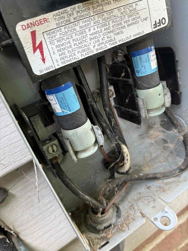 Responded to no-cooling complaint on residential air conditioning system. Upon arrival, confirmed system was running but not producing cold air. Performed diagnostic evaluation of outdoor condensing unit and electrical components. Measured incoming line voltage at disconnect box, which registered 172 volts—significantly below the required 208-240V range for proper compressor operation. Inspected disconnect panel and found aged fuses with visible corrosion on electrical connections and wiring terminals. Low voltage condition identified as primary cause of cooling failure, preventing compressor from operating at design specifications. Documented electrical readings and component condition with photos for customer records. Advised homeowner that utility company should be contacted to address inadequate voltage supply to the unit, as this falls outside HVAC system repair scope and represents an electrical service issue requiring utility provider intervention.