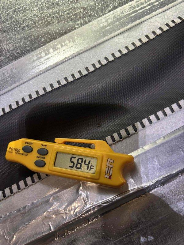 Completed cooling system tune-up on residential HVAC unit. Performed temperature diagnostics at supply duct measuring 58.4°F and electrical measurements at outdoor condensing unit showing 69.9V and 11.1A readings, confirming proper system operation and airflow performance.