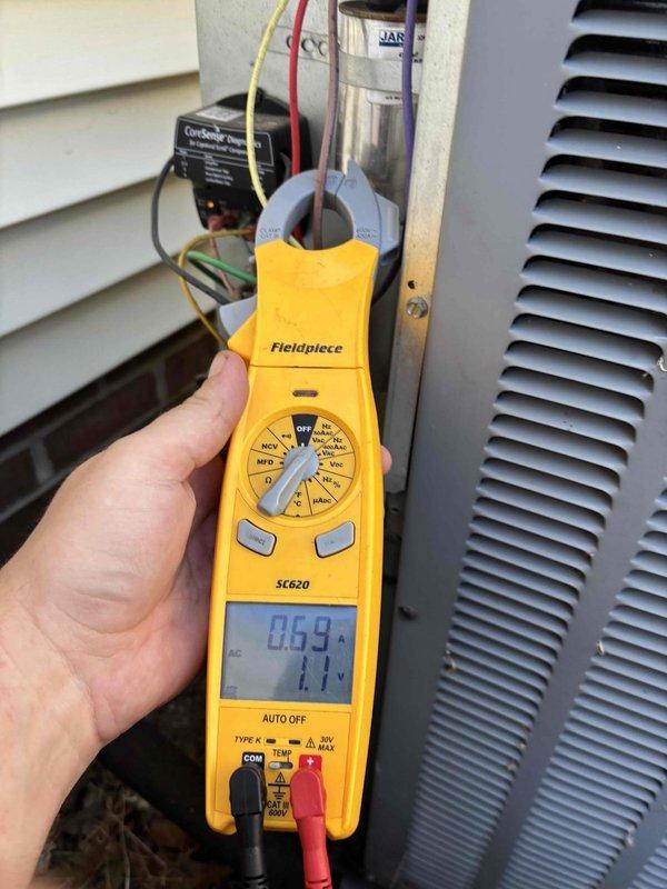 Completed cooling system tune-up on residential HVAC unit. Performed temperature diagnostics at supply duct measuring 58.4°F and electrical measurements at outdoor condensing unit showing 69.9V and 11.1A readings, confirming proper system operation and airflow performance.