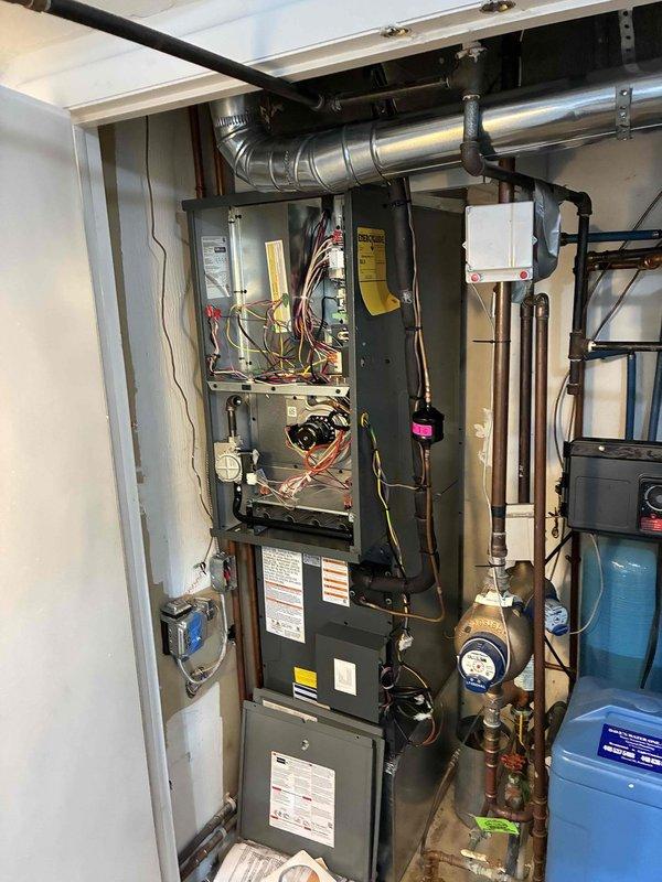 Completed installation of two full 80% efficiency heat pump systems in attic/closet mechanical space with side discharge configuration and integrated humidification. Systems installed include furnace units with associated ductwork, refrigerant lines, condensate drainage, electrical connections, and programmable thermostats leveled and wired to manufacturer specifications.