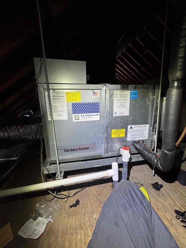 Returned to property to perform comprehensive refrigerant leak search on Unico System air handler located in attic space. Upon inspection, discovered significant frost and ice accumulation on suction line, indicating active refrigerant leak and loss of system charge. Conducted thorough leak detection procedures, identifying leak location on copper refrigerant piping. Documented frost buildup and system conditions with photographic evidence for service records.