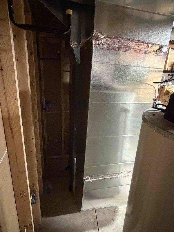 Completed heat pump installation in basement utility area with new ductwork and plenum assembly. System tested and verified operational at 72.5°F, with proper connections to existing infrastructure including copper refrigerant lines and insulated ductwork secured to structural framing.