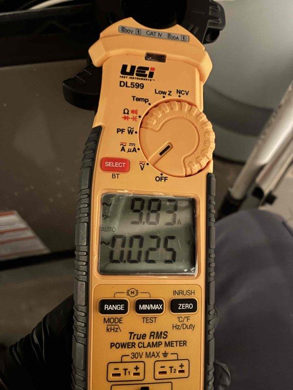 Completed comprehensive cooling system maintenance and performance verification. Utilized digital clamp meter to measure system amperage at 9.83 amps and recorded outdoor ambient temperature of 212°F, confirming proper electrical draw and documenting operating conditions for baseline performance data.