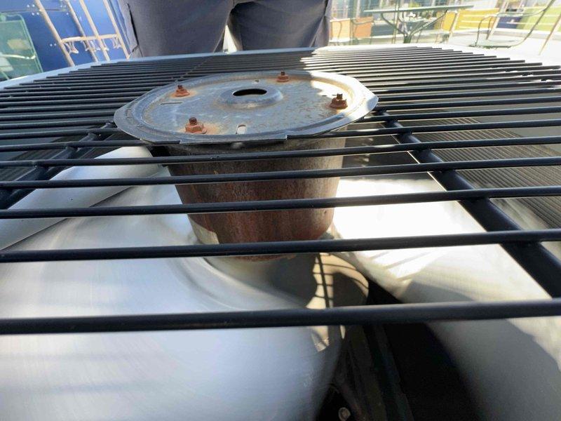 Completed scheduled cooling system maintenance on outdoor HVAC unit. Inspected condenser fan assembly, motor housing, and protective grille which showed normal weathering and corrosion consistent with outdoor exposure. Examined electrical disconnect and Cutler-Hammer components, verified proper labeling and safety warnings visible. Unit operational with all components functioning within normal parameters at time of inspection.