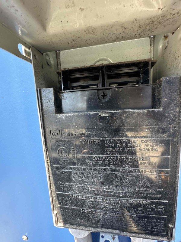 Completed scheduled cooling system maintenance on outdoor HVAC unit. Inspected condenser fan assembly, motor housing, and protective grille which showed normal weathering and corrosion consistent with outdoor exposure. Examined electrical disconnect and Cutler-Hammer components, verified proper labeling and safety warnings visible. Unit operational with all components functioning within normal parameters at time of inspection.