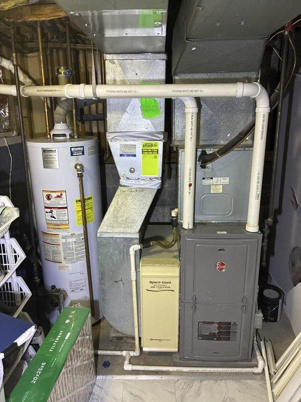 Completed comprehensive estimate for HVAC system and water heater replacement in residential property being prepared for sale. Evaluated existing gas furnace with Space-Gard filtration system, cylindrical water heater, and outdoor air conditioning condenser unit located beneath deck structure. Provided equipment replacement options and pricing information to enhance property marketability for upcoming home sale.