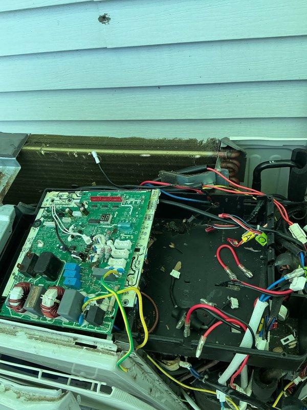 Responded to service call for 6-year-old Lennox mini-split system with rodent damage to electrical wiring. Upon arrival, inspected unit and confirmed mice had chewed through multiple wire connections affecting system operation. Customer reported circuit panel and control board had been previously replaced due to the same issue. Removed exterior panel to access internal components and assessed extent of damage to wiring harness, control board connections, and electrical pathways. Documented damaged coil section showing compression and deformation of fins, as well as accumulated debris throughout unit interior. Repaired and replaced compromised wiring connections using appropriate gauge wire and secure terminations. Cleaned debris from base compartment and verified all wire connections to green control board, capacitors, and component terminals were properly seated and secured. Tested system operation to ensure proper startup sequence and verified all electrical connections were function