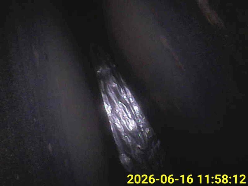 Performed furnace inspection as requested. Conducted internal visual examination of ductwork and heat exchanger components using inspection camera equipment. Identified metallic material, possibly deteriorated foil-backed insulation or detached duct liner, present within the duct system. Documented mineral deposits and residue buildup on interior duct surfaces. System inspection completed and findings photographed for record.
