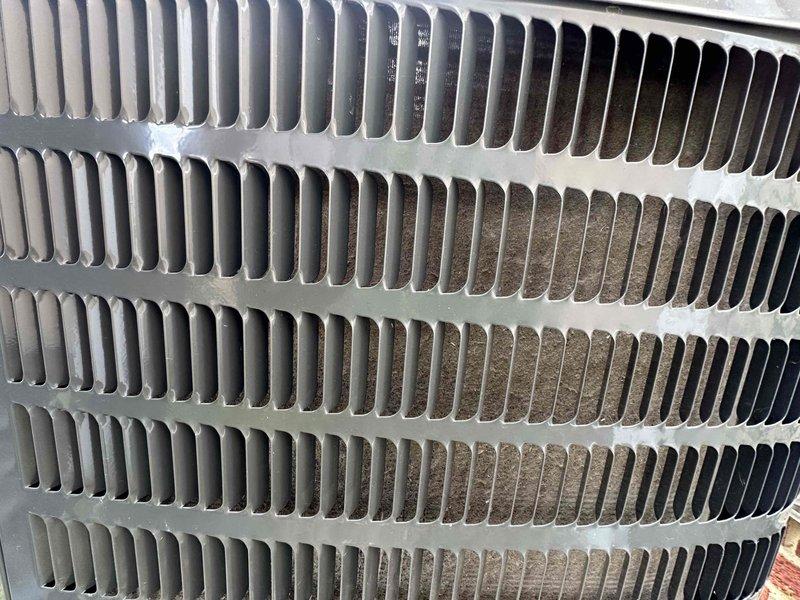 # HVAC Cooling Maintenance Completed

Performed comprehensive preventive maintenance service on residential air conditioning system as part of ongoing cooling season maintenance program. Conducted thorough inspection of outdoor condenser unit, evaluating heat exchanger coils and aluminum fin assembly for operational efficiency and airflow restrictions.

Upon inspection, identified moderate to heavy accumulation of dirt, dust, and debris on condenser coil fins, particularly concentrated in lower sections of the heat exchanger. Noted visible discoloration and brownish buildup on fin surfaces indicating extended exposure to airborne contaminants. Observed white mineral deposits and frost-like buildup on horizontal refrigerant tubes connecting upper and lower coil assemblies, suggesting potential drainage or moisture-related issues requiring monitoring.

Documented current condition of heat exchanger fins through photographic evidence, capturing areas of heavy soiling and oxidation on meta