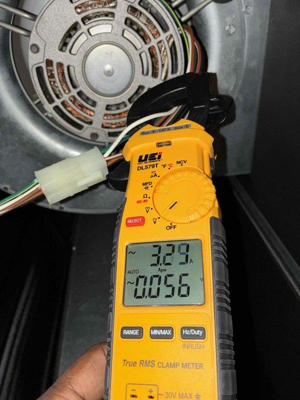 Performed routine cooling system maintenance on HVAC unit. Inspected condenser fan motor assembly, verified proper ventilation through motor housing, and checked electrical connections for security and integrity. Utilized digital clamp meter to measure motor amperage draw at 3.29 amps, confirming operation within manufacturer specifications. All electrical terminals and wire connections were found secure with no signs of overheating or deterioration. Motor assembly showed normal operational wear with adequate airflow through ventilation slots. System operating efficiently with no deficiencies noted.