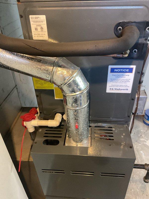 Completed comprehensive HVAC cooling maintenance and water heater flush and fill service as part of ongoing recurring maintenance program. Inspected and serviced residential furnace unit with associated ductwork, noting condensation present on metallic ductwork elbow near base of unit. Performed complete water heater flush and fill procedure on residential tank-style water heater, ensuring proper operation of all components and controls.