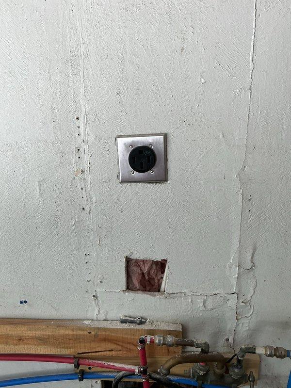 Completed warranty service for previous rewire installation. Addressed electrical outlet concerns, verified conduit routing and connections, and ensured all junction boxes and receptacles were properly secured and functioning. Documented existing conditions including plumbing infrastructure proximity and wall penetrations for quality assurance records.