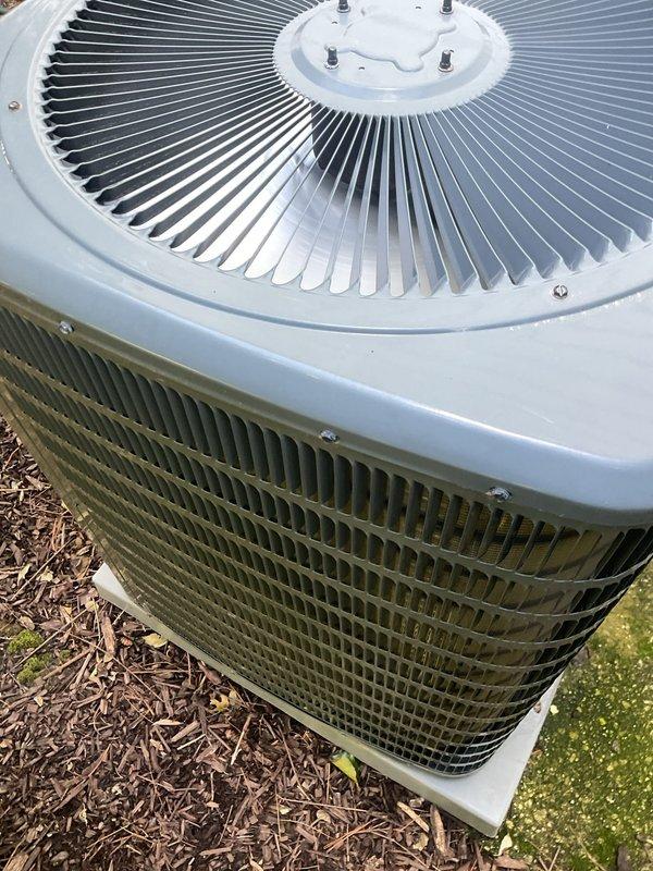 Completed comprehensive cooling system tune-up on residential air conditioning unit. Performed thorough inspection of condenser coils, noted significant organic growth and discoloration on exterior grille requiring attention, and verified proper operation of top-mounted fan assembly and heat exchanger components.