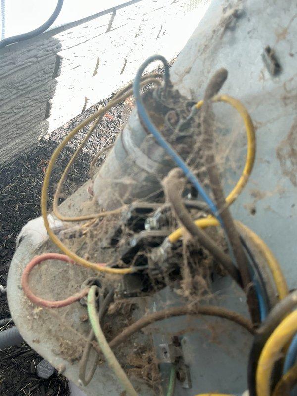 Responded to service call for reduced cooling capacity affecting entire home on 15-year-old air conditioning system. Performed comprehensive diagnostic evaluation and routine maintenance service on outdoor condensing unit. Upon inspection, found outdoor unit with significant debris accumulation, corrosion on electrical components, and heavy buildup of dirt, dust, and fibrous material obstructing airflow. Multiple wire connections showed signs of weathering and corrosion exposure. Cleaned condenser coil, removed debris from unit exterior and base, and inspected all electrical connections. Provided customer with equipment assessment and discussed replacement options given age and condition of existing system.