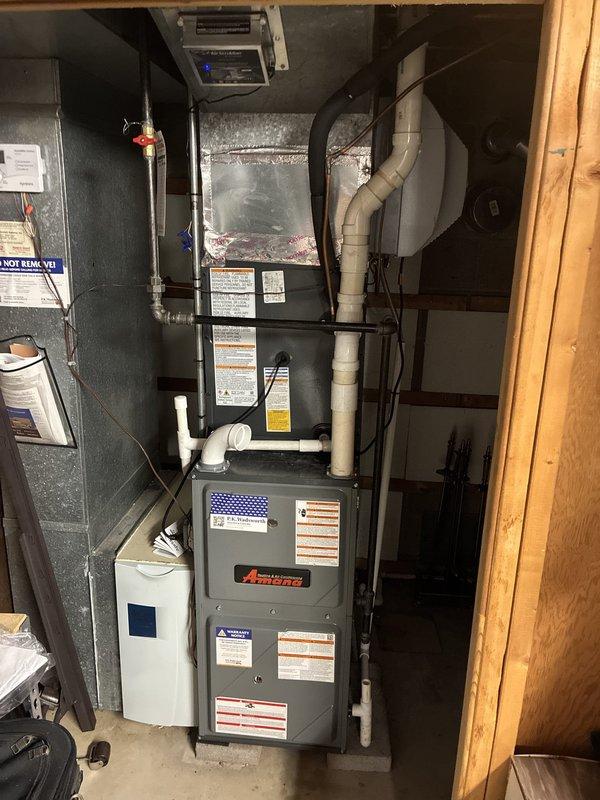 Completed installation of new Amana air conditioning system including outdoor condensing unit and indoor evaporator coil. Outdoor unit was positioned on concrete pad with proper clearances, electrical disconnect installed, and all refrigerant lines connected and tested. Indoor evaporator coil was mounted above existing furnace with insulated ductwork and drainage lines properly configured. System was charged, tested for proper operation, and all safety controls verified functional.
